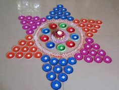 A beautiful small circle rangoli design featuring a star made from CDs on a white tile floor with candles in its center, perfect for festive occasions.
