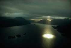 Aerial view of Dusky Sound near the southwestern tip of South Island in New Zealand, September 1971.Photograph by Gordon Gahan, National Geo #clouds #water #breakthrough #landscape #believe #photography #sunlight #spotlight #lake #abduction #rays #illumination