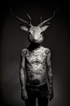 A stunning black-and-white tattoo design featuring a deer head in full coverage, showcasing intricate details on the chest.