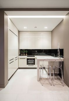 Tiny Small Compact white kitchen with floor to ceiling cupboards and black splashback. #interior #kitchen