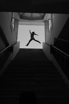 Unrecognizable silhouette of man jumping above stairs