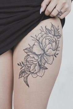 A beautiful peony flower thigh tattoo design, perfect for those who love floral patterns and delicate ink work.