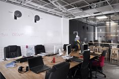 A modern advertising agency office designed by Cache Atelier, featuring sleek lines, minimalist decor, and an open floor plan.