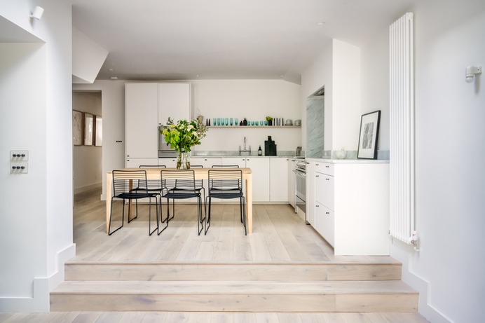 The open kitchen is in the addition. Stackable chairs from Hay surround a handcrafted table by Ethnicraft. Note the stylish light switches (at left): "My best up-cycle!" gushes Olivia. "A client was throwing out her Forbes & Lomax invisible switches with antique bronze rotary dimmer. These are like pieces of art."