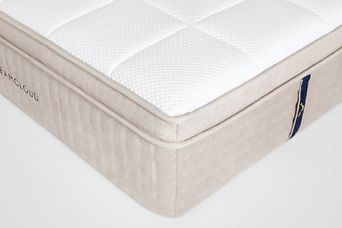 DreamCloud's white hybrid mattress with pillows