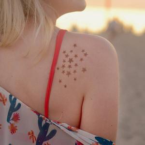 Stellar - woman with star henna tattoo on shoulder Shine like the star you are with this modern henna tattoo design that you can easily apply yourself with Mihenna's sticker stencils for luminescent results.