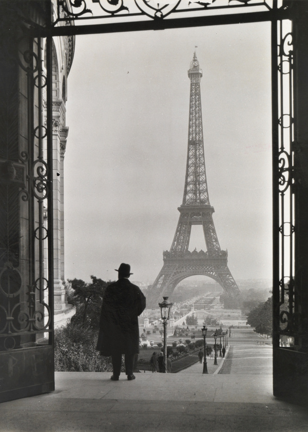 Man looks out on the Eiffel Tower.Photograph by Clifton R. Adams, National Geographic #eiffel #white #black #tower #photography #vintage #and #man #suit #50s