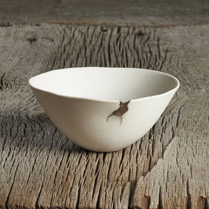 Chipped pearl bowl on soft wood surface (960×960)