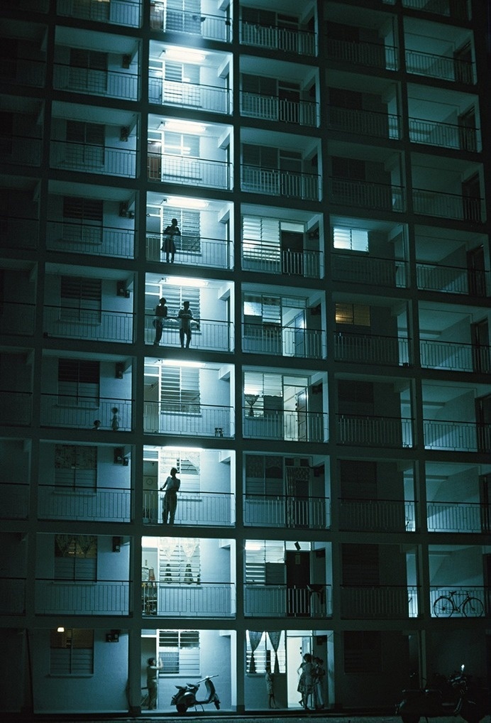 People stand on their balconies in the night air, Singapore, 2001 #urban #apartments #skyrise #home #balcony #photography #building #architecture #singapore