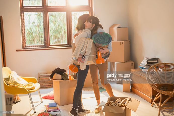 Mother and daughter hugging unpacking boxes in apartment : Stock Photo