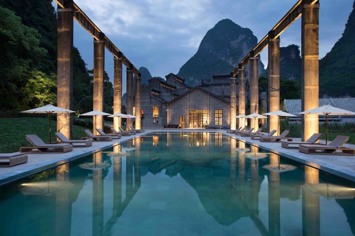 Outdoor, Large Pools, Tubs, Shower, Landscape Lighting, Large Patio, Porch, Deck, Back Yard, Trees, and Grass An old sugarcane dock was turned into a swimming pool, which offers views of the Karst mountains and Li River from a distance.