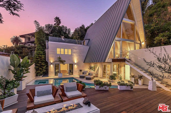 Perched above a long driveway is this stylish designer remodeled mid-century A-frame. A well laid out three-bed, three-bath urban retreat just above the "Strip". Walls of glass open to views of Downtown and the Argyle. The flexible open floor plan is flooded with natural light, living, and dining open to a gourmet kitchen, loft and den, and an extraordinary rooftop deck. The state-of-the-art media room opens to the private redone pool. Completely walled and gated for maximum privacy.