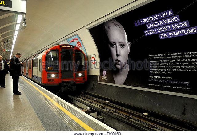 London, England, UK. St Paul's underground station. Cancer campaign poster featuring bald woman undergoing chemotherapy - Stock Image