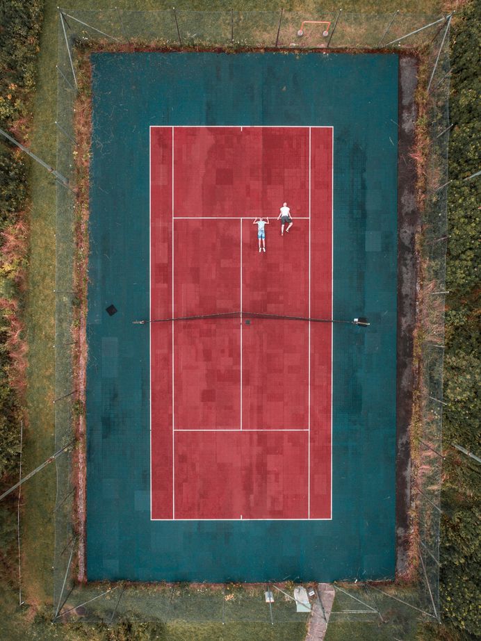 A drone looking down at an outdoor tennis court.