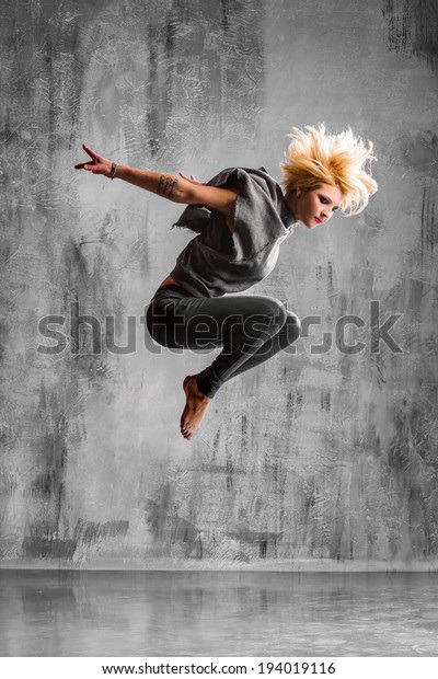 young beautiful dancer posing on studio background