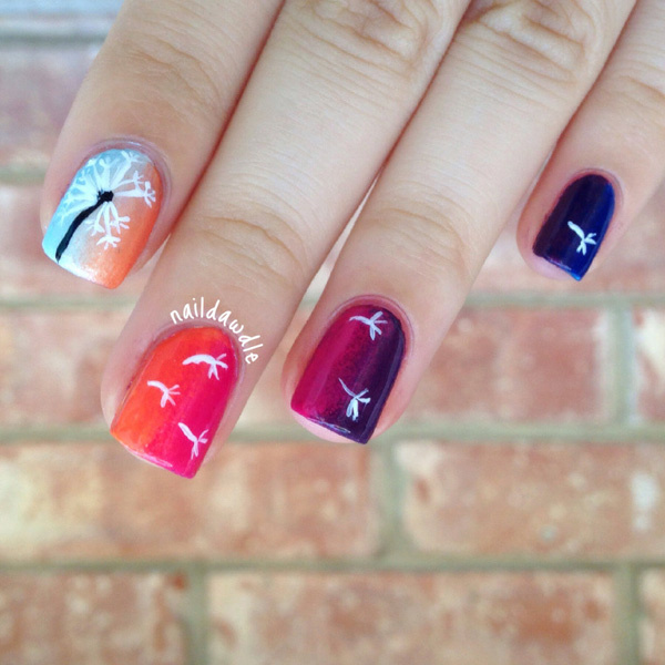 A pretty white colored dandelion over colorful gradients polishes. The petals are scattered all the nails like blown by the wind.
