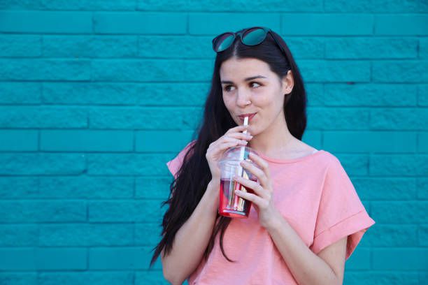 Portrait of young woman drinking soft drink