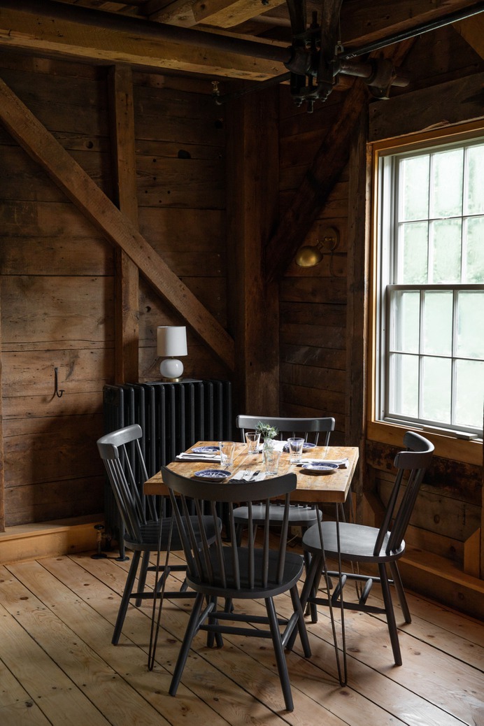 French built the tables with help from a local carpenter, using salvaged wood and metal hairpin legs. The chairs are from Hayes Unfinished Furniture in Brewer, Maine, painted in Benjamin Moore's Iron Mountain.