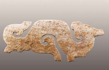 A NICELY CARVED S-SHAPED DRAGON PENDANT WITH AN INCISED PATTERN OF LINKED, SQUARED SCROLLS