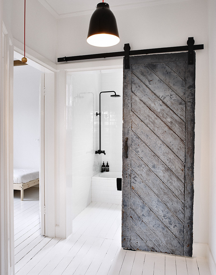 Black #reclaimedwood sliding #barndoor. #SwedishSummerHouse by #MrFrag. Photo by #TerenceChinPhotography. #slidingdoor