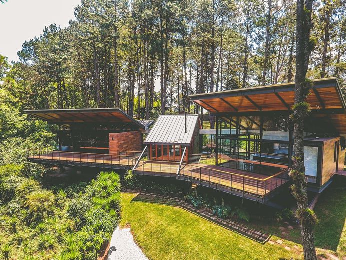 Exterior, Wood Siding Material, Metal Roof Material, House Building Type, Concrete Siding Material, Butterfly RoofLine, and Gable RoofLine The pitched roofs are topped with CINDU metal cladding. Photo 5 of 15 in A Small Guatemalan Hut Gains a Thoughtful Glazed Expansion