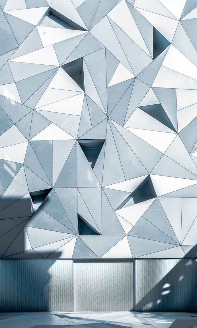 A pattern with gray and white triangles on a building facade in Madrid