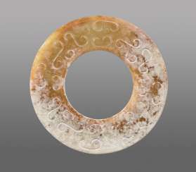 A REFINED HUAN RING WITH SUBTLY CARVED ABSTRACT-LOOKING DRAGON HEADS