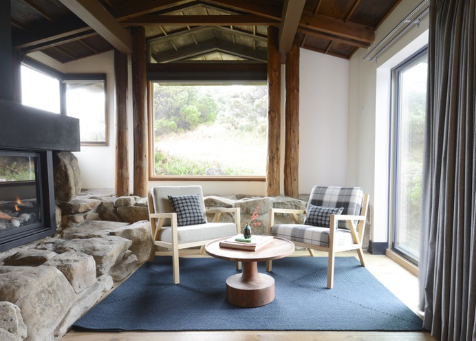 Ocean view suites have their own living rooms. Here, oak wood chairs upholstered in wool (one gray, one plaid) frame a midcentury-inspired coffee table.