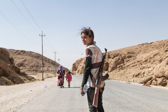 Menina Yezidi carregando armas para proteger a família dos ISIS (Estado Islâmico do Iraque e do Levante)