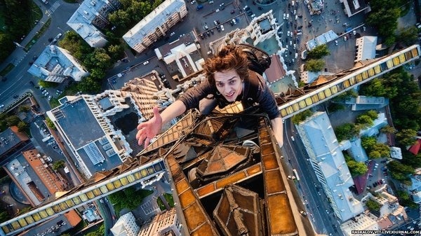 Man clinging to a star at the top of a high rise building in Moscow. #photography