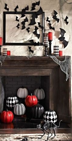 Vampire Red, Black and White Halloween Mantel Ideas | Digs Digs - a stylish mantel with bats and red and checked candles and a fireplace filled with checked, striped and red pumpkins