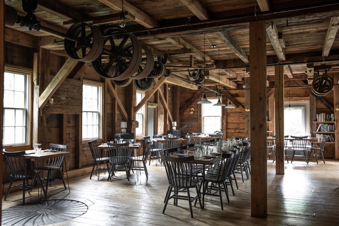 Inside, remnants of the old mill remain: pulley systems and an old millstone, inlaid in the floor. French fitted the dining room simply, and all herself, with hand-built tables and painted spindle-back chairs. She also had a vent and air duct installed to facilitate the working kitchen.