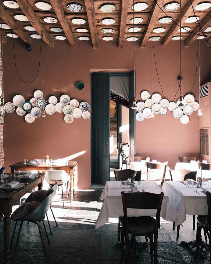 In the main dining room, even the ceiling is used as a display canvas for a collection of ceramic plates.
