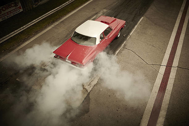 Classic car doing a burnout at a racetrack