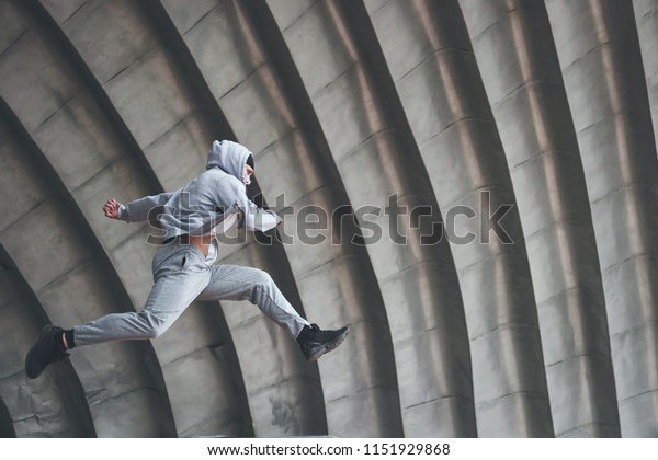 The man outdoors practices parkour, extreme acrobatics