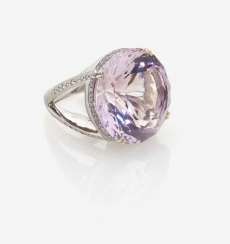 A MODIFIED COCKTAIL RING DECORATED WITH AN AMETHYST AND BRILLIANT-CUT DIAMONDS