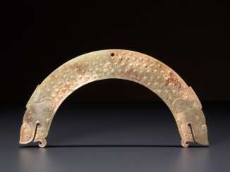 A FULLY DETAILED, RARE, SEMI-CIRCULAR , DRAGON-HEADED HUANG ARCHED PENDANT WITH A PATTERN OF RAISED SCROLLS
