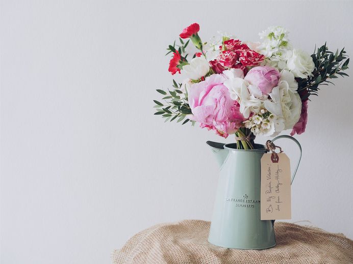Valentine's Day floral arrangement of roses, carnations, and peonies in a vintage pitcher