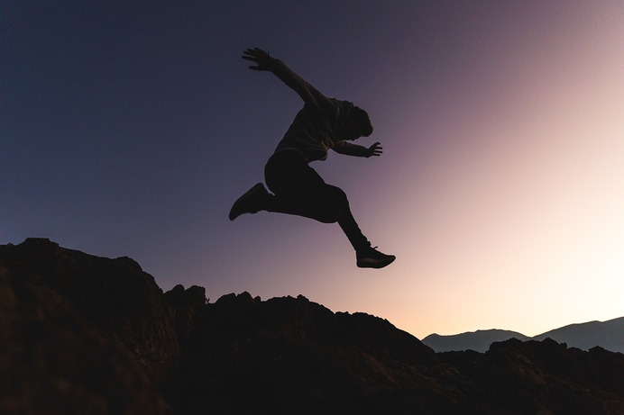 man jumping above mountains
