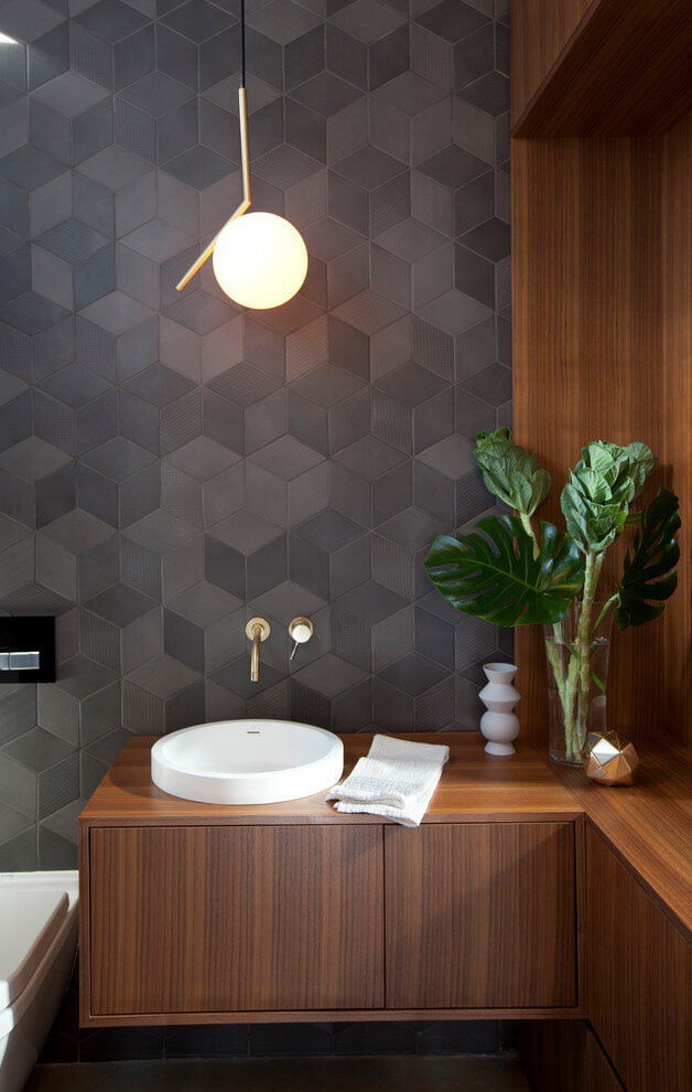 Grey geometric tile wall with dark walnut finish cabinets