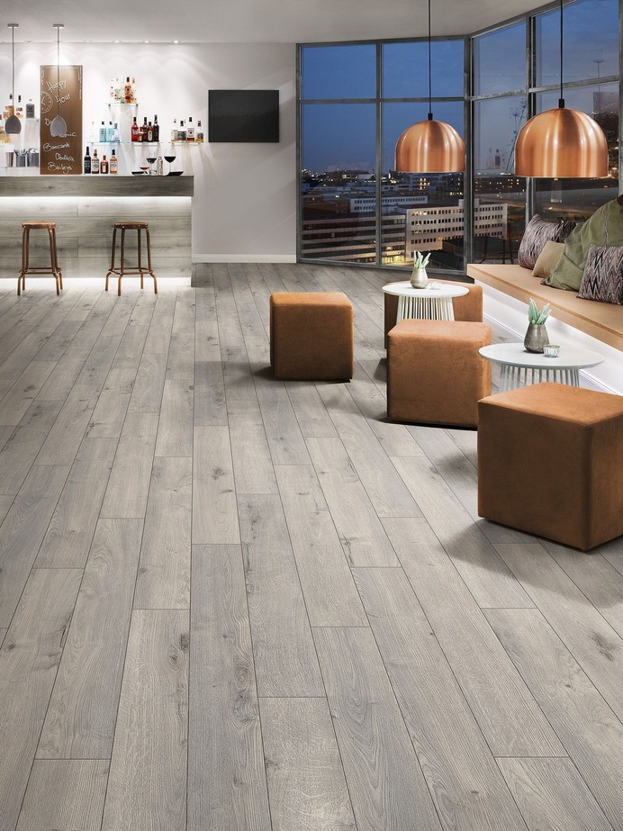 Naturalna podłoga dla jasnego apartamentu
Naturalne światło lubi naturalny wystrój wnętrz, a w obecnie oddawanych do użytku apartamentach często ściany są bardzo przeszklone. Dlatego dla światła wpadającego sporą przestrzenią okienną, ciekawym wzorem podłogi będzie użycie paneli Krono Original o synchronicznej strukturze naturalnego dębu.