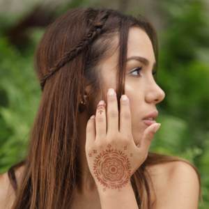 Blossom - woman with mandala henna tattoo on back of hand Easy mandala henna designs are accessible for beginners and experts alike with Mihenna's sticker stencils. Try one today for convenient and beautiful henna tattoos.