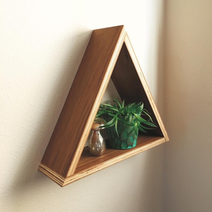 Wall hanging triangle shelf made from walnut plywood. By Corey Ward in collaboration with Love, Fannie Interiors.
