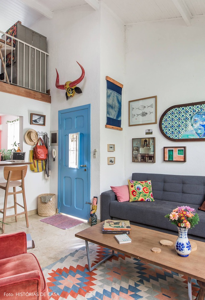 Sala com mezanino e porta pintada de azul