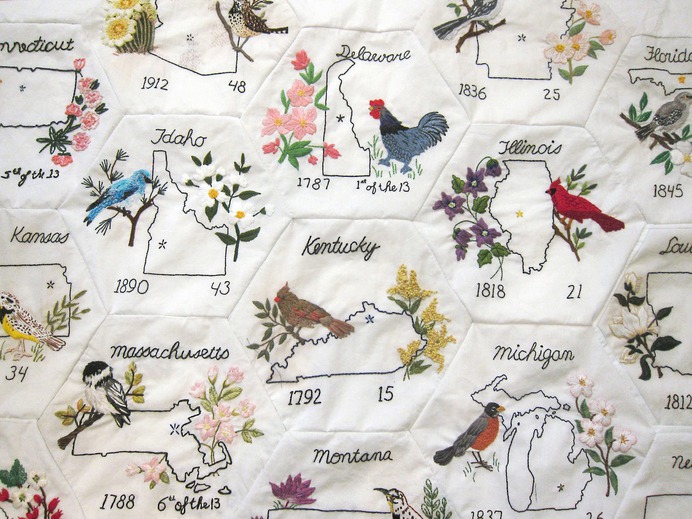 Detail shot of Rita's quilt. The hexagons are decorated with the outlines of the 50 U.S. states, along with their official birds and animals.