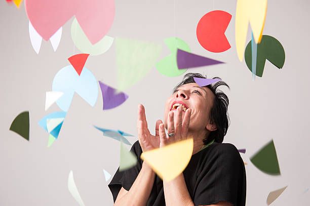 Woman smiling at falling pieces of colorful paper