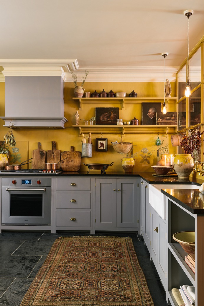 Parker sourced many of the decorative touches—confit jars, oil paintings, Spanish baskets—from flea markets and antique fairs. The integrated stove is by Wolf. The countertops are Belgian Blue Limestone.