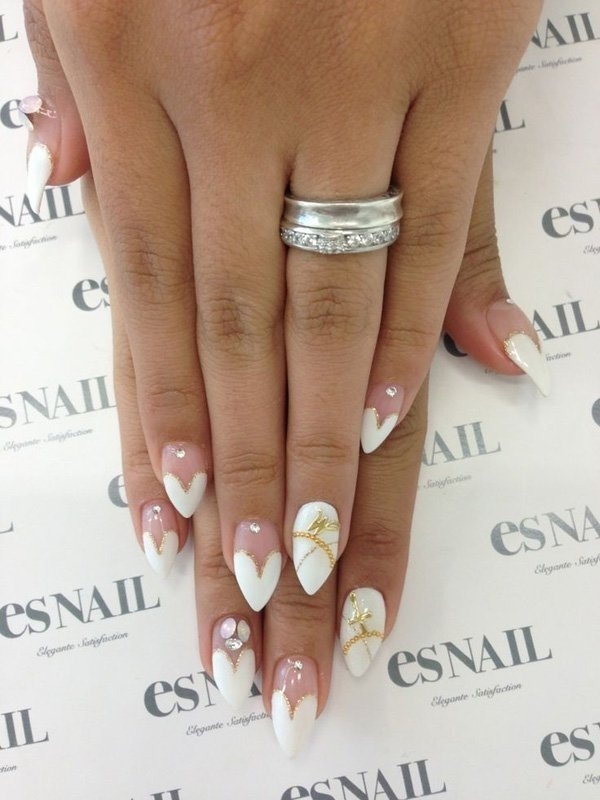 Purity inspired nail art with white heart shapes on the nail tips, simple yet elegant. Shades of white and silver beads are popular because