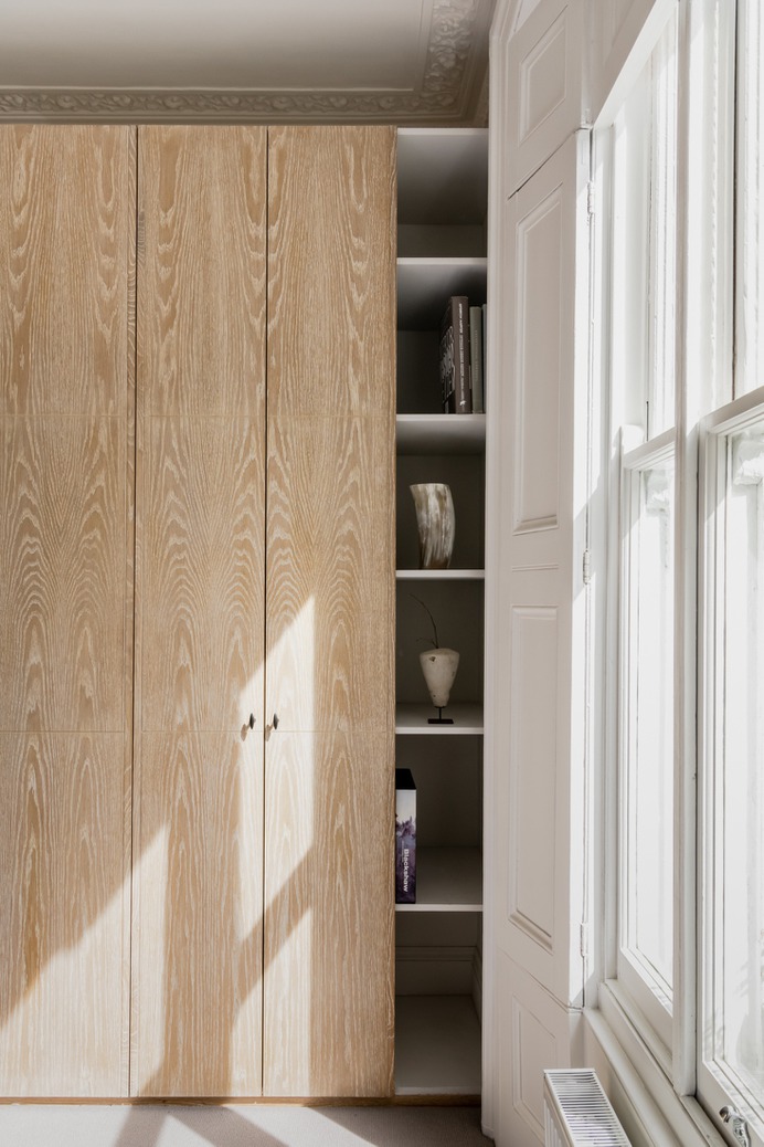 Olivia's wardrobe closet is a another castoff from a client. "I played with the idea of building the wardrobes in, but I'm pleased with the decision to build shelves on either side and expose the traditional cornicing. I think this makes the room feel bigger. My contractor cut the oak doors in half vertically so we can open them easily without bashing into the bed," she says.