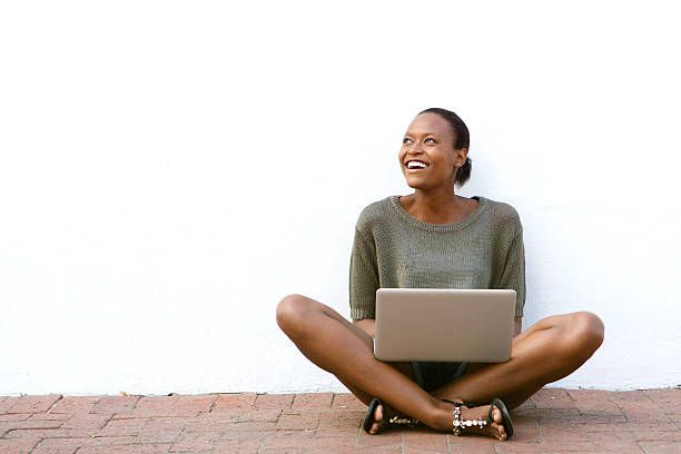 Happy african american woman sitting with laptop